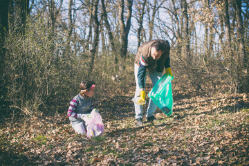 father and daughter gathering garbage in the park
