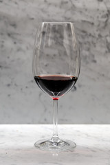 Red wine in a glass isolated, grey background.
