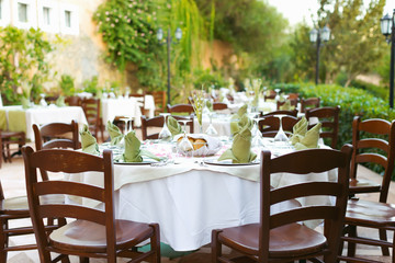 Fototapeta na wymiar Empty italian restaurant with well-laid tables - selective focus
