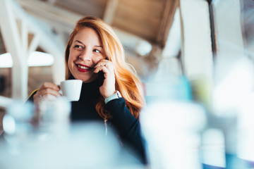 Young woman using smartphone in a cafe