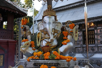 Silver Ganesha with orange flowers and bananas