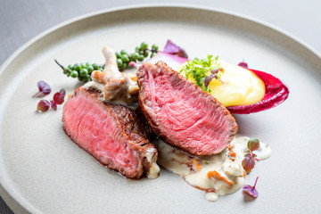 Barbecue wagyu point steak from beef sliced with chanterelle in sauce and mashed potatoes as top...