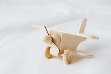 Wooden toy plane stands on a white background