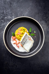 Gebratenes Schellfisch Fisch Filet mit Safran Reis und Krabben in Krebs Sauce als Draufsicht auf...