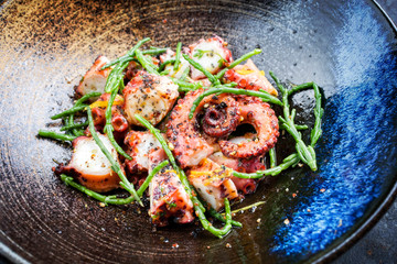 Traditional French octopus braised cooked with Salicornia, lemon curd and spice as closeup in a...