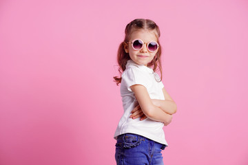 Portrait of beautiful smiling cute model in trendy round sunglasses. Casual 7 y.o. girl posing...