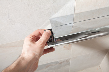 Using of modern chromium-plated plumbing. Repair and renovation in bathroom. Restroom. Wetroom. Hand press.