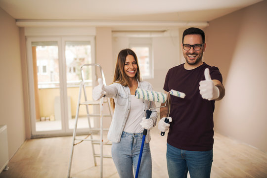 Young couple painting their apartment.