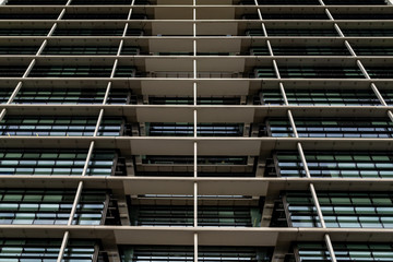 Bottom view glass grey square Windows of modern city business building skyscraper. Receding perspective, movement forward and up.