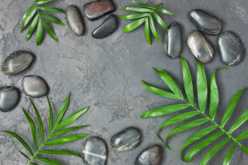 Obraz na płótnie Canvas Spa stones and leaves on grey background