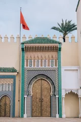Königspalast von Fez mit der roten Flagge Marokkos an einem schönen Nachmittag mit blauem Himmel in Marokko, Afrika © SmallWorldProduction
