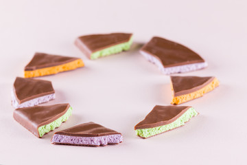 Chocolate with fruit filling on pink background. Slices of chocolate with blueberries, mint and...