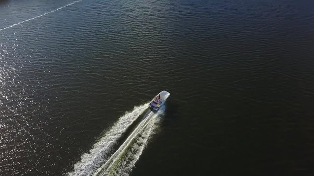 AERIAL: angled down track of a boat speeding through water near Key Largo, Florida.