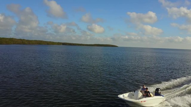 AERIAL: surpassing a boat as it speeds through the ocean terrain near Key Largo, Florida.