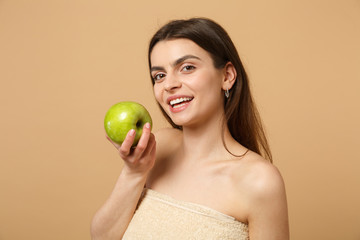 Close up brunette half naked woman 20s with perfect skin, nude make up hold apple isolated on beige...