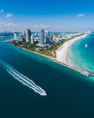 Aerial view of Miami Beach with speedboat in view - obrazy, fototapety, plakaty