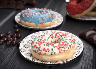 colorful glazed donuts on black wooden table