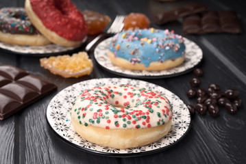colorful glazed donuts on black wooden table