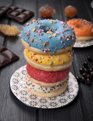 colorful glazed donuts on black wooden table