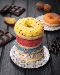 colorful glazed donuts on black wooden table