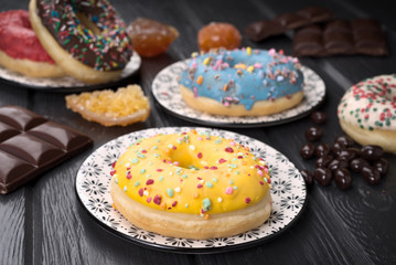 colorful glazed donuts on black wooden table