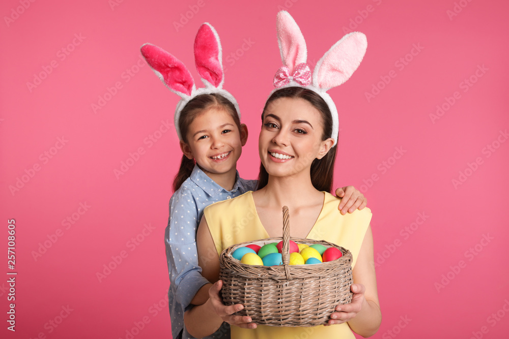 Sticker Mother and daughter in bunny ears headbands with Easter eggs on color background