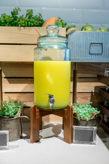 Pineapple juice in the glass container on wood stand.