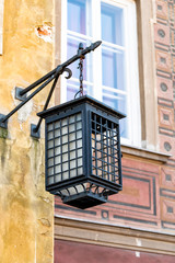 Closeup of yellow orange lamp lantern historic traditional architecture in Warsaw, Poland Old town historic street during day