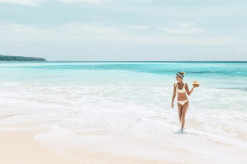 Fototapeta na wymiar Woman drinking coconut on the tropical beach