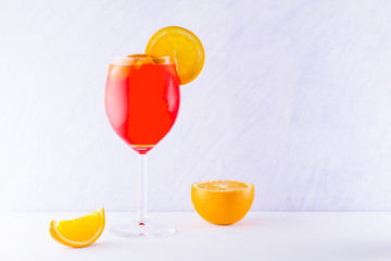 Cocktail aperol spritz on white background. Summer alcoholic cocktail with orange slices. Italian cocktail aperol spritz on white board. Trend drink