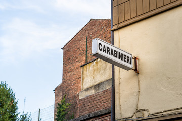 Naklejka premium Chiusi, Italy Empty street in small town village in Umbria Tuscany during day with Italian police Carabinieri sign