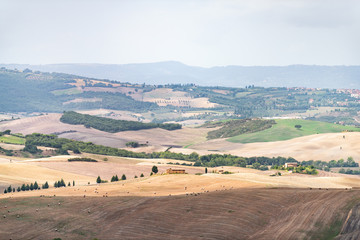 Obraz premium Countryside in Val D'Orcia Tuscany, Italy with aerial bales rolling plowed brown hills and villas with farm landscape meadow fields high angle