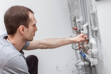 Installation and setting the new gas boiler for hot water and heating. Technician servicing the house heating system.