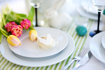 Beautiful table setting with crockery and flowers for Easter celebration.