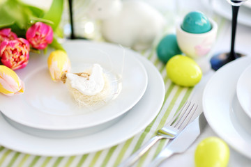 Beautiful table setting with crockery and flowers for Easter celebration.