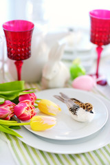 Beautiful table setting with crockery and flowers for Easter celebration.