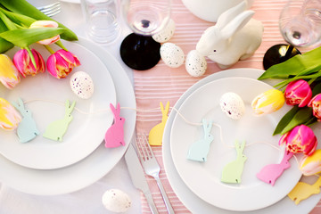 Beautiful table setting with crockery and flowers for Easter celebration.