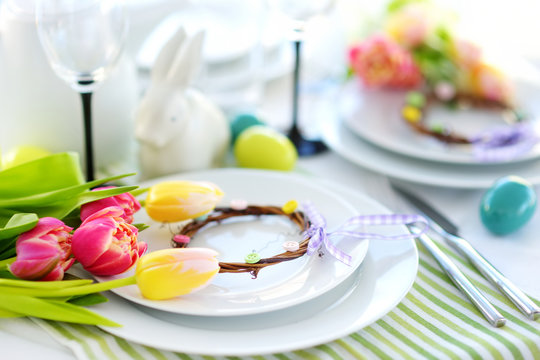 Beautiful table setting with crockery and flowers for Easter celebration.