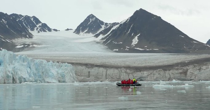 Expedition sailing near iceberg on Rubber zodiak boat in the North Pole 