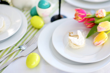 Beautiful table setting with crockery and flowers for Easter celebration.