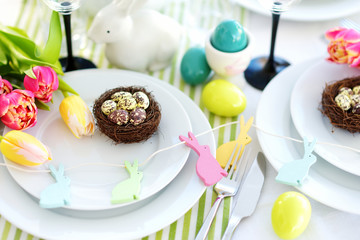 Beautiful table setting with crockery and flowers for Easter celebration.