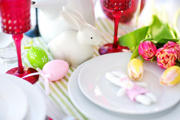 Beautiful table setting with crockery and flowers for Easter celebration.
