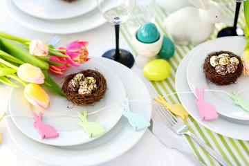 Beautiful table setting with crockery and flowers for Easter celebration.