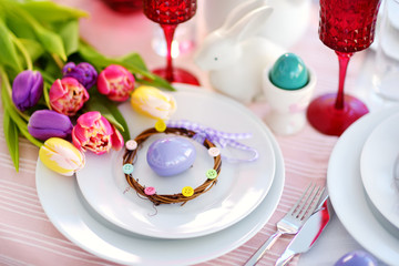 Beautiful table setting with crockery and flowers for Easter celebration.