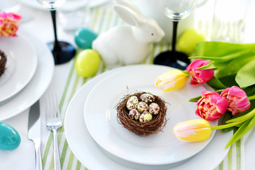 Beautiful table setting with crockery and flowers for Easter celebration.