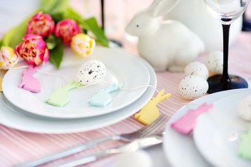 Beautiful table setting with crockery and flowers for Easter celebration.
