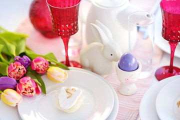 Fototapeta na wymiar Beautiful table setting with crockery and flowers for Easter celebration.