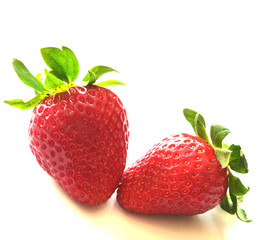 Red strawberries with green leaves isolated on white background.