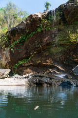 Small waterfall with emerald water pool