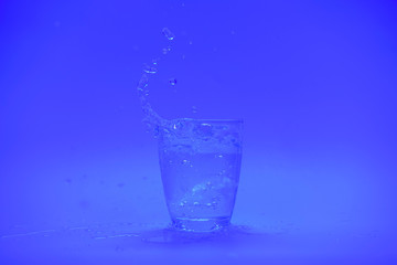 Glass of water with splash isolated on white background